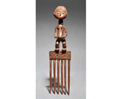 An Ashanti comb Ghana with a standing figure, 29.5cm, long.