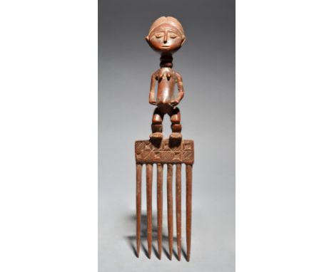 An Ashanti comb Ghana with a standing figure, 29.5cm, long.