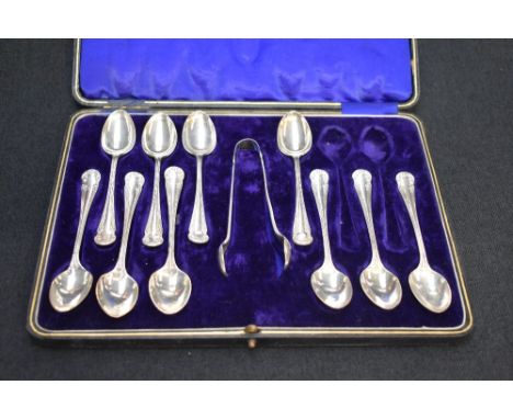 A part set of George V silver teaspoons and sugar tongs, each with scroll decoration to terminals, marks for Sheffield 1919, 