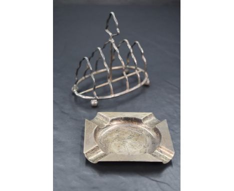A late Victorian silver four-division toast rack, of shaped arch form with central carrying handle, raised on four ball feet,