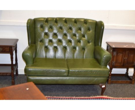 A two seater green leather wing back sofa