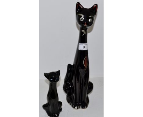 A 1970'S stylised cat , with elongated neck , silvered eyes and bow, picked out in red , 35cm high ; another smaller , 15cm h