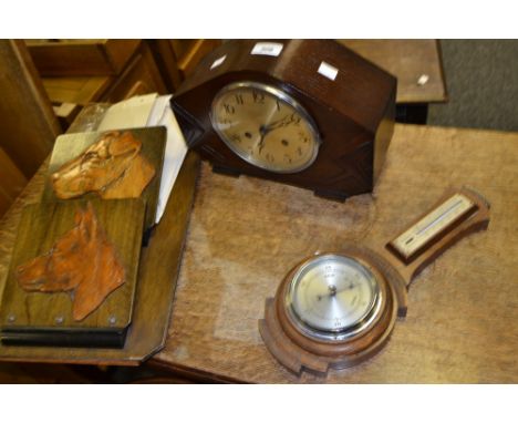 An Art Deco shaped mantel clock, silvered dial with Arabic numerals, c 1940; an Art Deco oak barometer; a wall newspaper rack