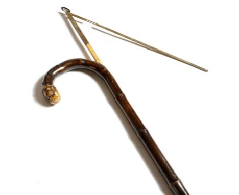 An early 20th century bamboo horse measuring stick, with a crook handle above a silver button revealing a boxwood measure, wi