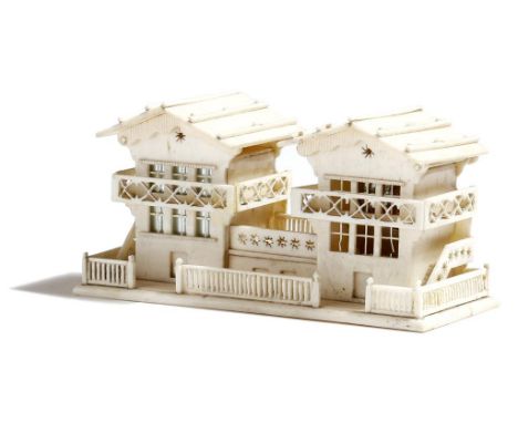A late 19th century Swiss bone inkstand, in the form of two chalets, the roofs hinge to reveal a white metal inkwell and a sa