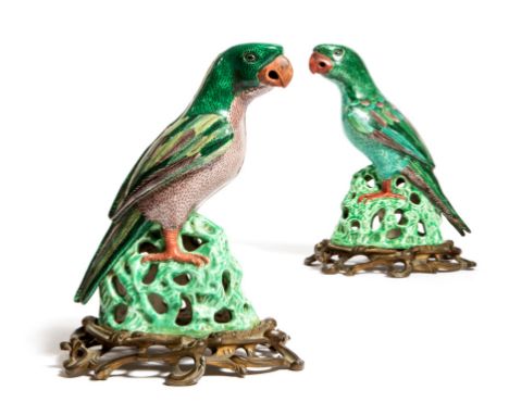 Two Chinese famille verte models of parrots, each on an openwork rocky base, raised on scroll decorated ormolu bases, 19th ce