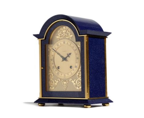 A gilt brass and lapis lazuli style mantel clock retailed by Garrard, with an eight day Swiss movement, the arched dial with 