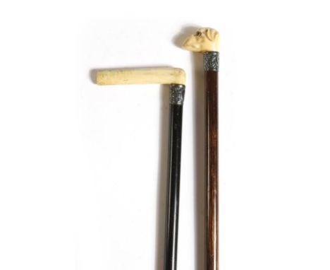 λ An Edwardian palmwood swagger stick, with an ivory handle carved as a bulldog's head, with glass eyes, the embossed silver 