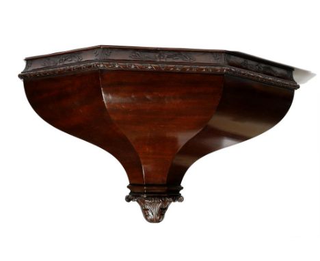 A late Victorian mahogany wall bracket in 18th century style, of faceted tapering form carved with leaf scrolls and a ribbon 