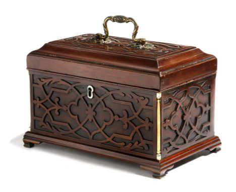 λ A George III mahogany tea caddy, with blind fret carved decoration, the hinged lid with a gilt brass handle revealing three