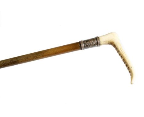 λ A rhinoceros horn hunting whip by Swaine, the antler horn handle above a silver ferrule, inscribed 'SWAINE' with indistinct