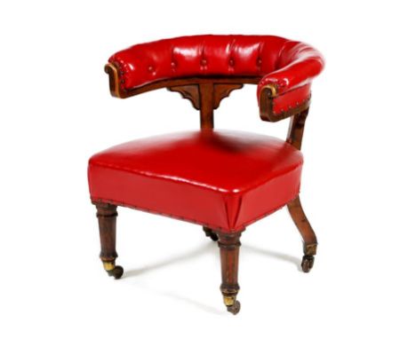 An early Victorian oak Gothic desk chair, button upholstered with red leatherette, on octagonal tapering legs with brass caps