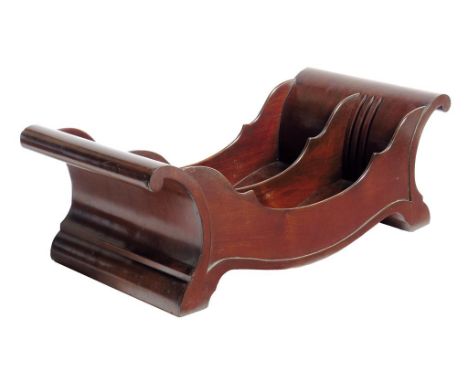 A George III mahogany cheese coaster, of panelled scroll form and with an adjustable division on sunken brass roller castors,