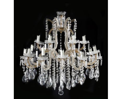 A continental gilt metal and glass eighteen light chandelier, of open scroll form, hung with drops, lusters and pendants, fir