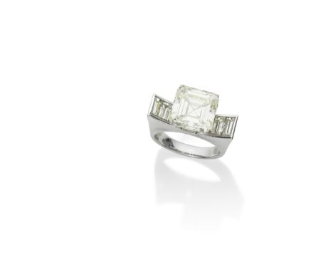 A DIAMOND RINGThe step-cut diamond, weighing 8.87 carats, in a raised setting, to a sculptural concave mount, channel-set wit