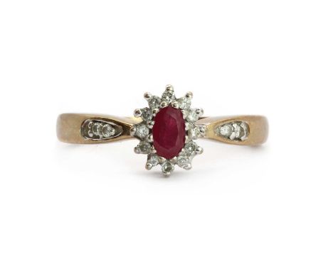 A 9ct gold ruby and diamond cluster ring,an oval mixed cut ruby claw set to the centre, to a surround of round brilliant diam