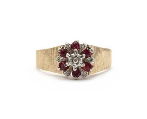 A 9ct gold ruby and diamond cluster ring,an eight cut diamond star set to a raised collet, to a surround of circular cut rubi