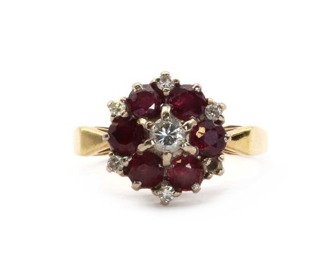 An 18ct gold ruby and diamond target cluster ring,a brilliant cut diamond to the centre, with a border of round mixed cut rub