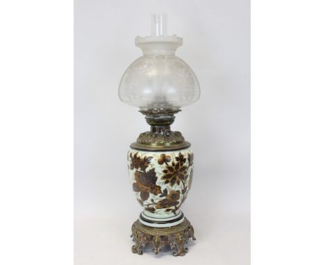 Late 19th / early 20th century oil lamp with Veritas burner and ceramic vase reservoir with foliate decoration, on an ornate 
