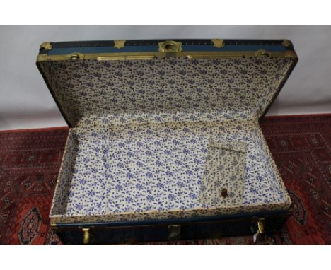 Large blue and black steamer trunk with metal trim and fastenings, by Langmuir, four-ply leather grab handle, paper-lined wit