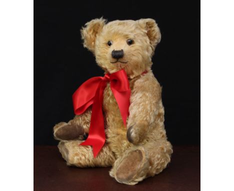 A 1930's Chiltern golden mohair jointed teddy bear, glass eyes with remains of brown painted backs, pronounced shaven snout w