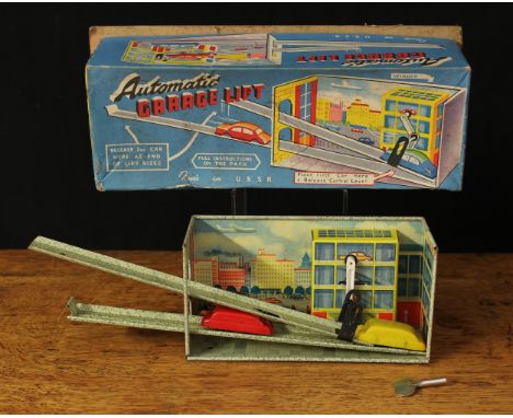 A 1960's Cowan de Croot Ltd U.S.S.R. made tinplate and clockwork automatic garage lift, printed lithograph detail, boxed with
