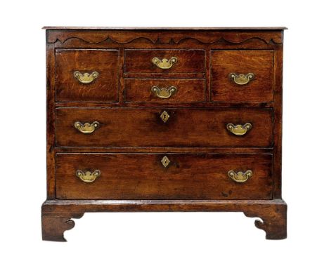 A 18th century oak chest of drawers. With two short central drawers flanked by two deep drawers over two long drawers on brac