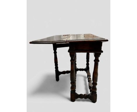 A 17th-century walnut table The single leaf with a gate support. 82cm wide x 61cm with the leaf raised, 68cm high