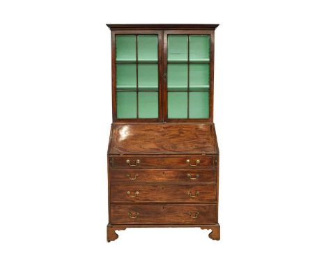 A George III mahogany bureau bookcase. The upper section with twin glazed doors enclosing three shelves over a fitted bureau 