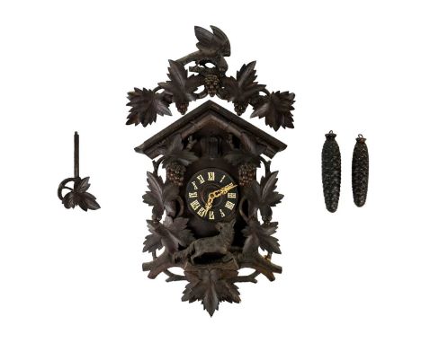 A Black Forest cuckoo wall clock. Early 20th century, the cresting carved with a bird, with fruiting vines and a fox below, w