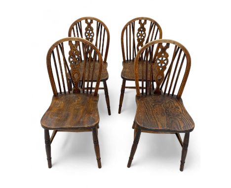 A set of four elm Windsor hoop and stick back chairs. With wheel back vase splats. (4)