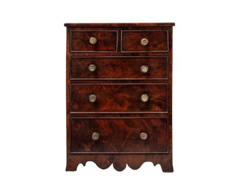 A Regency flame mahogany miniature or collector's chest. Fitted two short and three long drawers, above a shaped apron and on