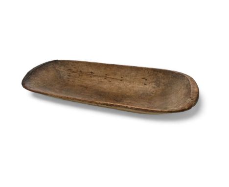 An impressive treen flour trough  The boat shaped trough with a re-inforced metal lip to one end, evidence of historic repair