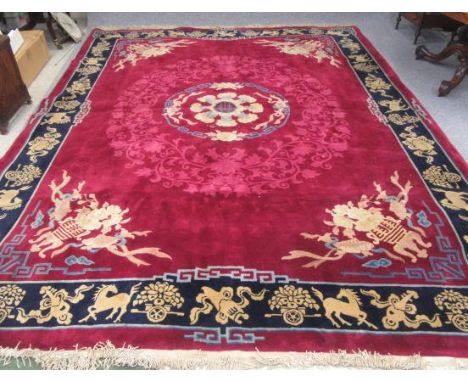 A CHINESE WASHED AND FRINGED CARPET, the raspberry pink field centred by a cream and blue floral roundel, the corners with si