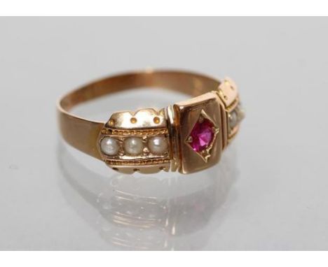 A LATE VICTORIAN 15CT GOLD RING centred by a gypsy set ruby within panelled shoulders each set with three seed pearls, Cheste