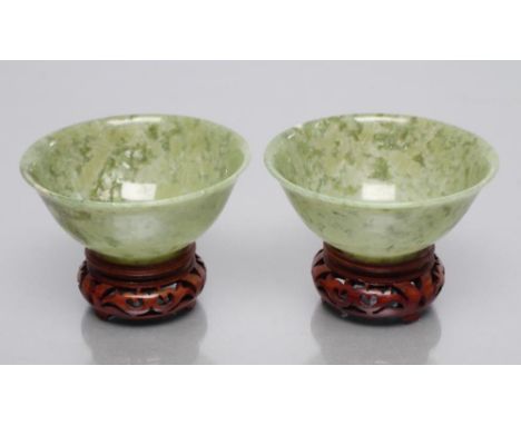 A PAIR OF TURNED AND POLISHED JADE BOWLS of plain circular form, 3 3/4" diameter, 1 1/2" high, with wood stands (Est. plus 21