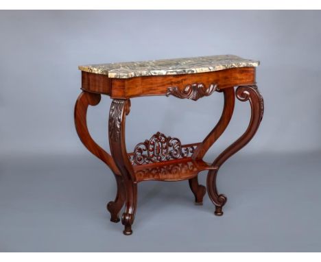 A VICTORIAN CARVED WALNUT CONSOLE TABLE of serpentine oblong form with marble top, leaf carved frieze, acanthus sheathed scro