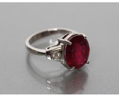 A RUBY RING, the oval facet cut stone of approximately 8cts claw set to angular shoulders each point set with a round brillia