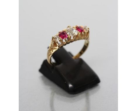 AN EDWARDIAN FIVE STONE RUBY AND DIAMOND RING, the central cushion cut diamond flanked by two claw set rubies and two further