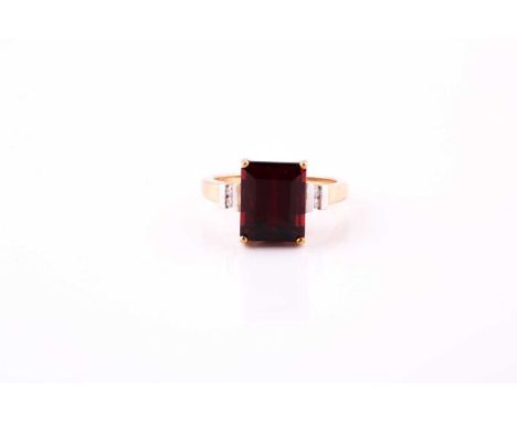 A ruby and diamond ring the step-cut ruby, measuring 10.7mm x 8.7mm x 6.1mm, between duos of brilliant-cut diamonds, approxim