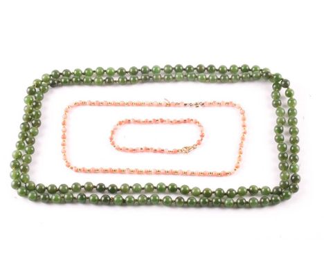 A jade bead long necklace, beads averaging 8mm diameter, 126cms long; and a pink coral bead necklace, with yellow spherical s