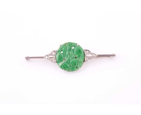 A jade and diamond bar brooch, 1930s, the central jade panel carved with fruit, millegrain set to either side with eight-cut 