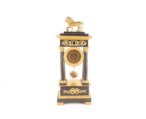 A French Charles X portico clock, late 19th century, Empire style, surmounted by a gilt metal lion, supported upon four patin