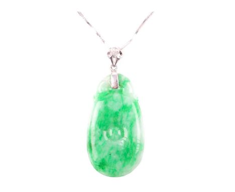 An 18ct white gold and jade pendant, of carved oval form, surmounted with a white gold and diamond mount, jade 3.3 cm long, s