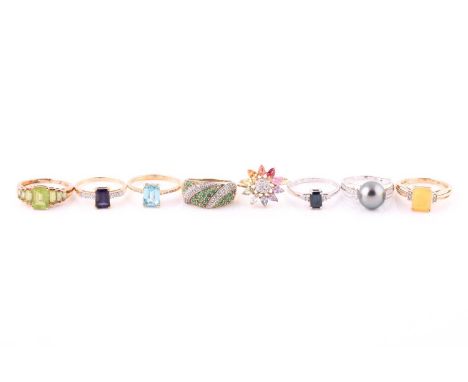 A collection of gem-set ringsEach set with vari-cut gems such as opal, sapphire, zircon, peridot, topaz and a black Tahitian 