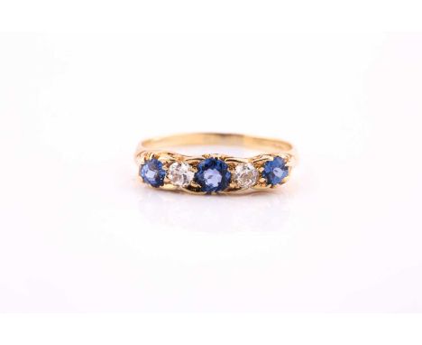 A sapphire and diamond five stone half hoop ring; the circular cut sapphires and round brilliant cut diamonds in carved claw 