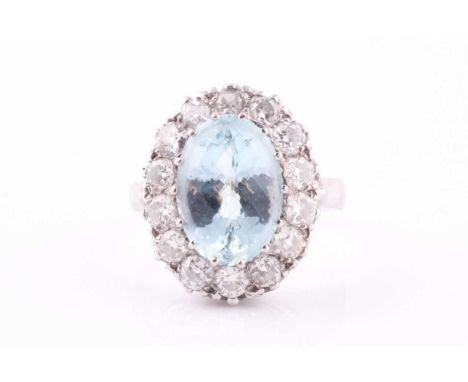An aquamarine and diamond cluster ring, the oval faceted aquamarine within a surround of round cut diamonds, estimated total 