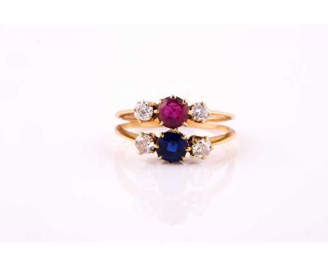 A ruby, diamond and sapphire ringOf bifurcated design, composed of two bands, each set with either a circular-cut sapphire or