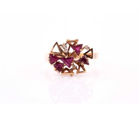 A ruby and diamond ring; the open work abstract cluster set with five mixed trillion and trapeze cut rubies and four round br