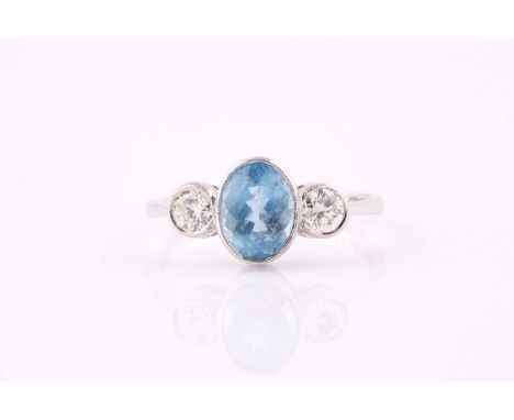 An aquamarine and diamond three stone ring, the 8 x 6mm oval aquamarine with a round brilliant cut diamond to either side, al